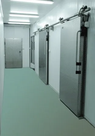 Pasillo de almacenamiento con tres puertas corredizas de una hoja para cámara de refrigeración.