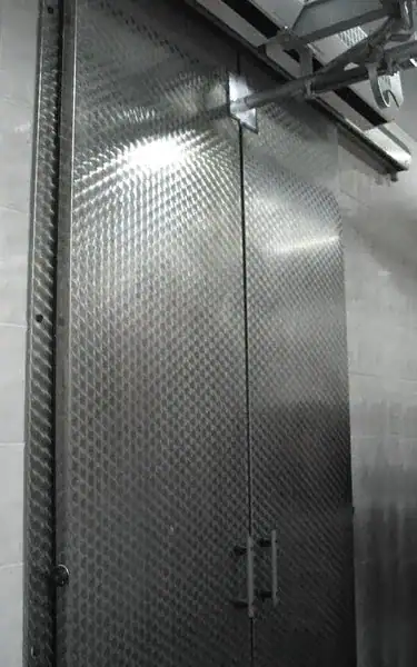 Puertas frigoríficas industriales corredizas de doble hoja para acceso amplio.