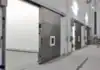 Sistema de acceso con múltiples puertas corredizas a prueba de gas con ventanas en pasillo técnico.