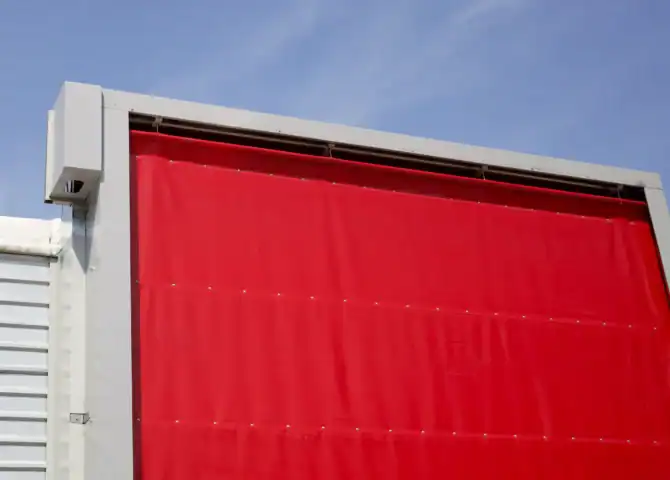 detalle del mecanismo y marco de una cortina de portón de hule rojo